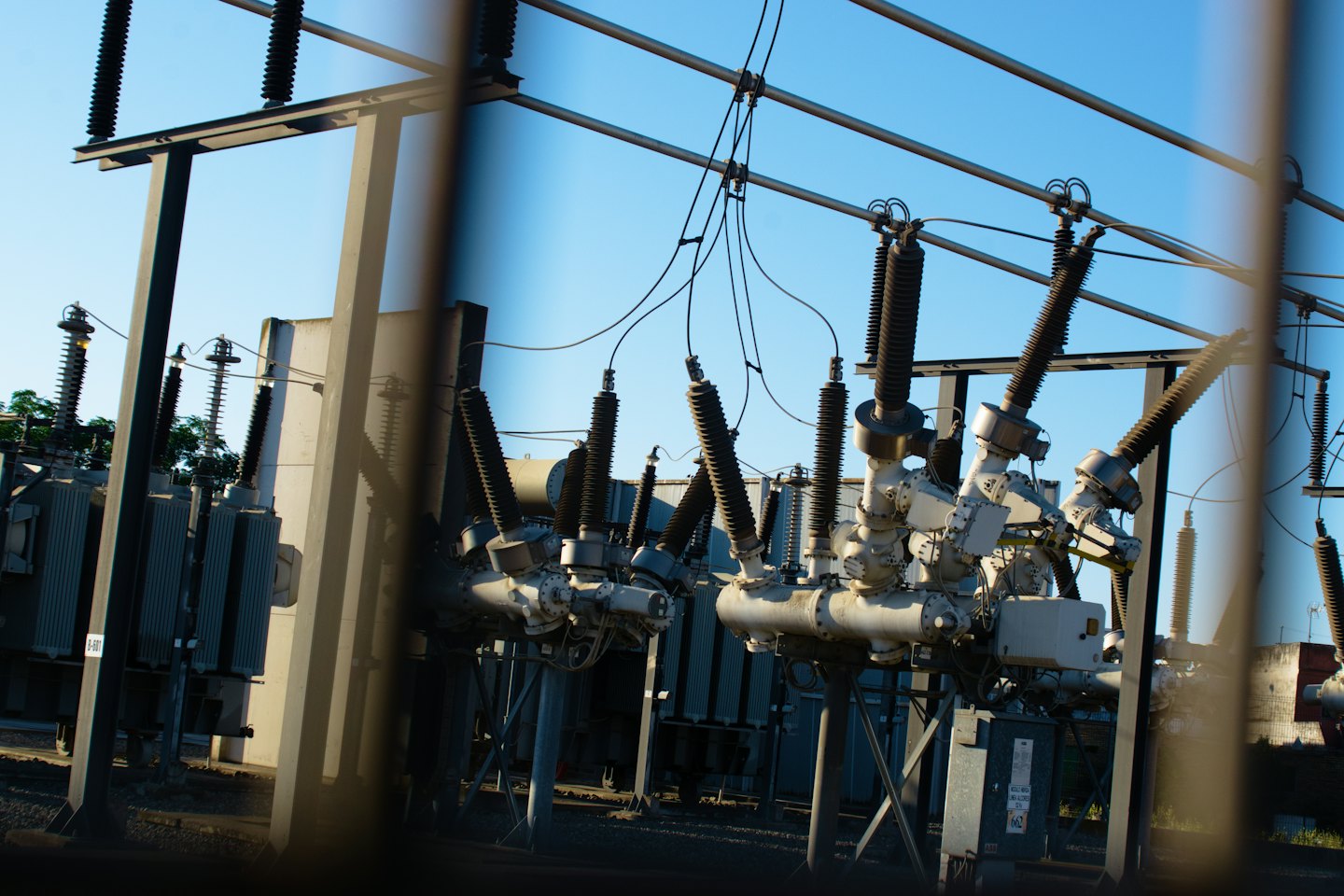 Electrical components and transformers stand inside an industrial power substation.